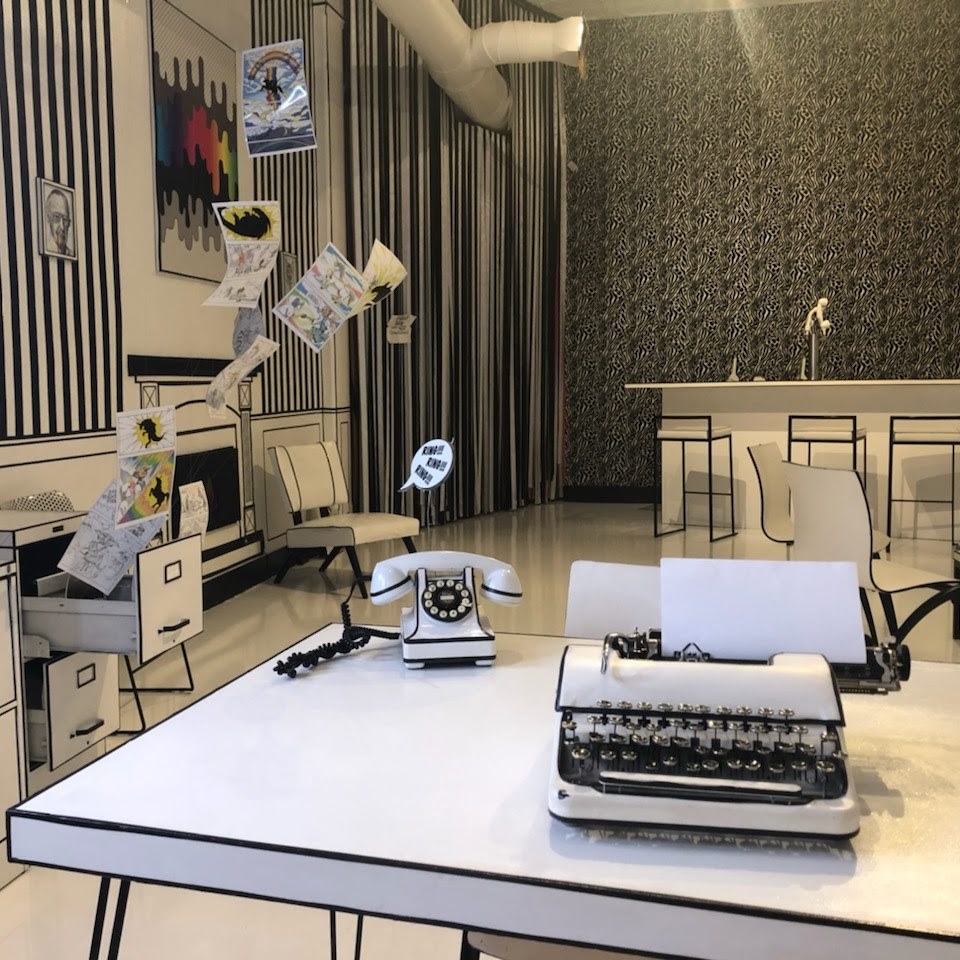 a bedroom with a bed and desk in a room